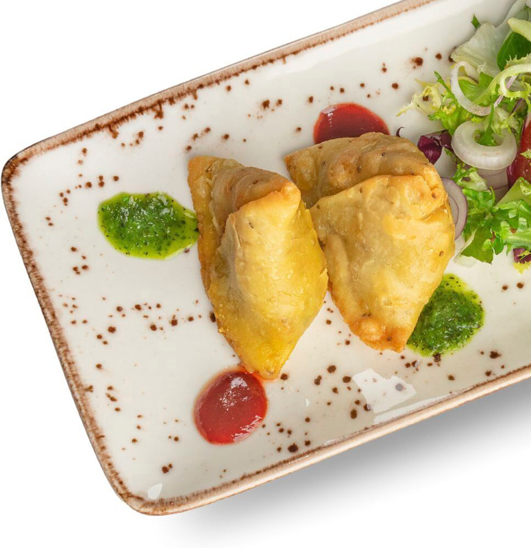 Vegetable Samosa (L, K). Täytetyt friteeratut nyytit vihanneksilla, tarjoillaan sipulisalaatin ja kastikkeiden kanssa.

