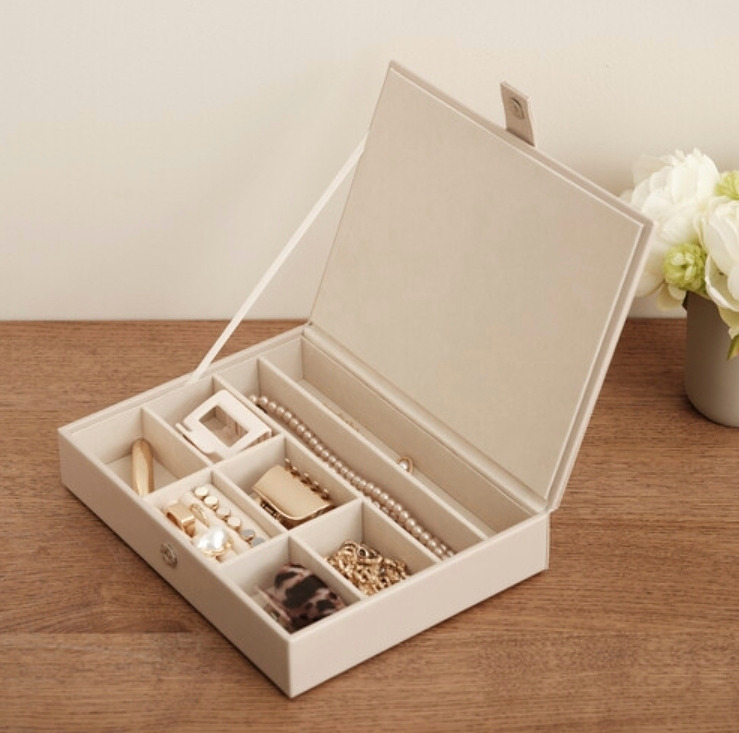 Ylellinen korurasia samettia – kannessa magneettilukitus. Voidaan pinota päällekkäin muiden saman sarjan kannettomien korutarjottimien kanssa.