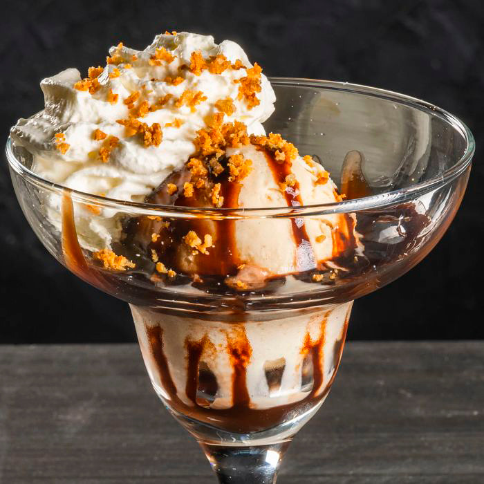 Piparkakkujäätelö, suklaakastike, kermavaahto ja piparimuru.